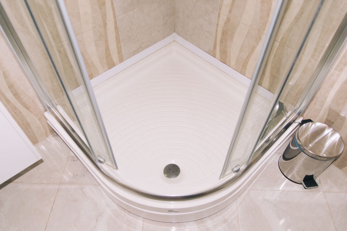 Khay tắm góc với vách kính và phễu thoát sàn