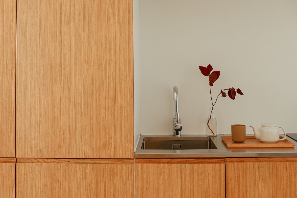 Chung Cư Wabi Sabi: 7 Bí Quyết Thiết Kế Căn Hộ Đẹp Chuẩn 2026 6 Khu bếp chung cư Wabi Sabi với tủ gỗ tự nhiên tối giản