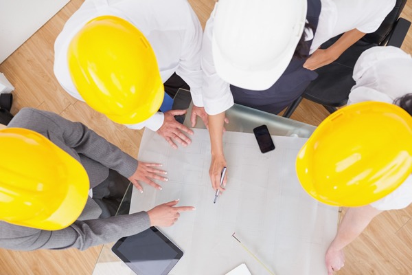 Giải Pháp Kiểm Định Chất Lượng Công Trình Để Bảo Vệ Ngôi Nhà 2 Kỹ sư đội mũ bảo hộ kiểm tra bản vẽ đảm bảo kiểm định chất lượng công trình xây dựng